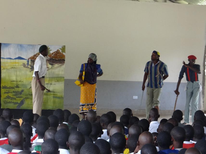 Blue Swallow Working Group volunteers performing a skit to students at Nambale Boys High School, Busia