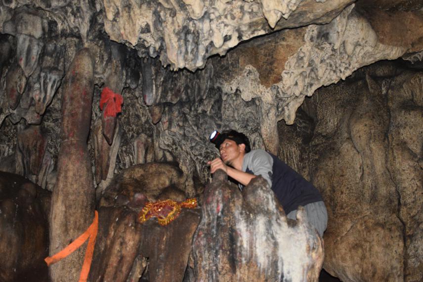 Project leader observing bats in roosting site (holy cave) in study area.