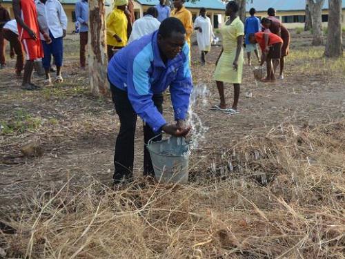 Club facilitator also watering plants after mulching.
