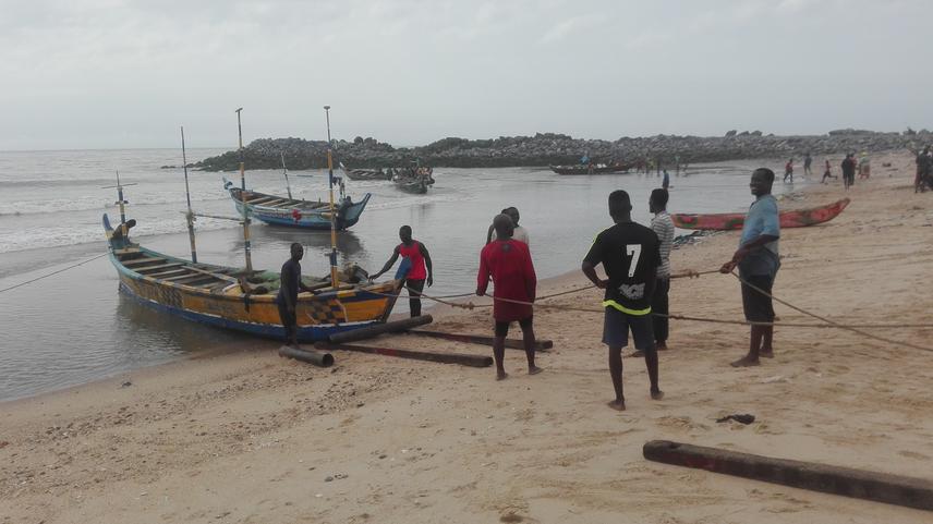 Project team member interactin with fishermen at Jamestown while helping them pull their net.