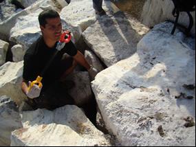 Collecting samples between the rocks.