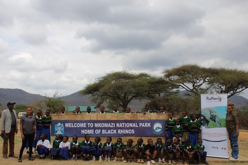 A group of students gather at the entrance gate of Mkomazi National Park, ready to start their exciting field trip to explore wildlife and nature. ©Loyce Majige.