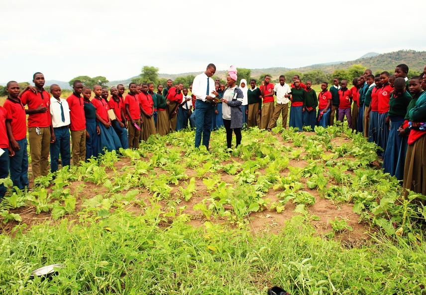 Ms Happyness briefing on importance of school vegetable gardens to Mirumba secondary students. ©Bahati Kayanda.